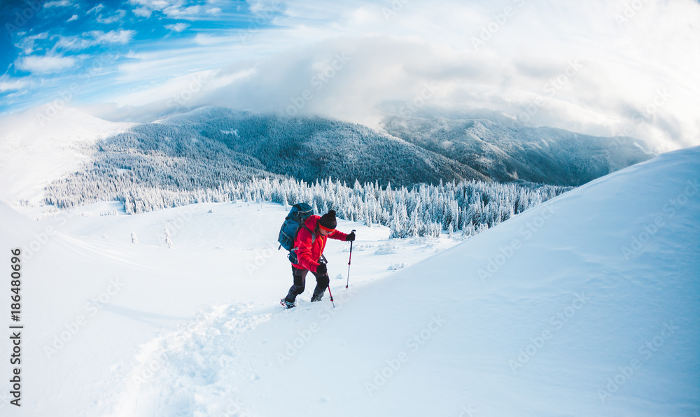 A man in snowshoes in the mountains.