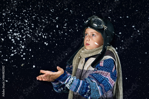 Portrait of a boy in a warm sweater and hat .  Effect snowfall