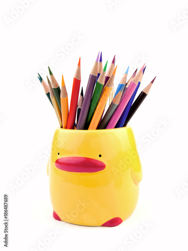 Many color pencils in cute ceramics cup or box isolated on the white background, front view.