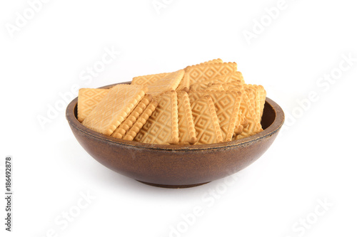 Square cookies in plate isolated on white background.  Pile of sweet biscuits in wooden bowl.