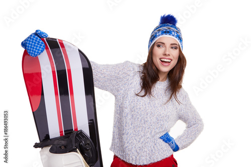 Woman wearing winter suit holding a snowboard in studio