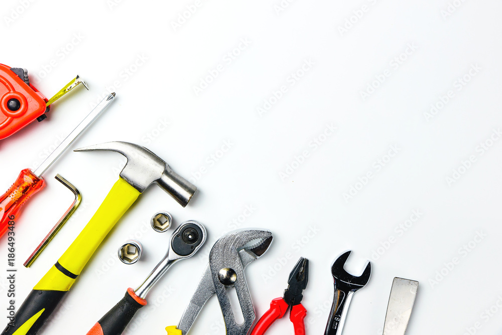 Top view of Working tools,wrench,socket wrench,hammer,screwdriver,plier,electric drill,tape measure,machinist square and safety glasses on white background.flat lay design for construction concept Top view of Working tools,wrench,socket wrench,hammer,screwdriver,plier,electric drill,tape measure,machinist square and safety glasses on white background.flat lay design for construction concept