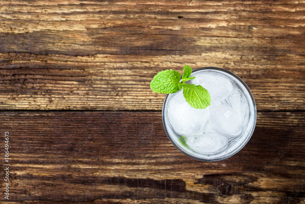Glass of water with ice and mint on wooden background. Top view. Glass of water with ice and mint on wooden background. Top view.