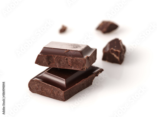Macro photo of Chocolate bar. Broken pieces over white background