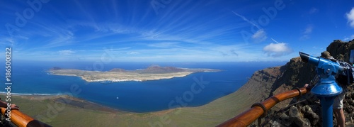 Telescope on vantage point on Mirador del Rio, Lanzarote, Spain. Breathtaking view of La Graciosa island in the background