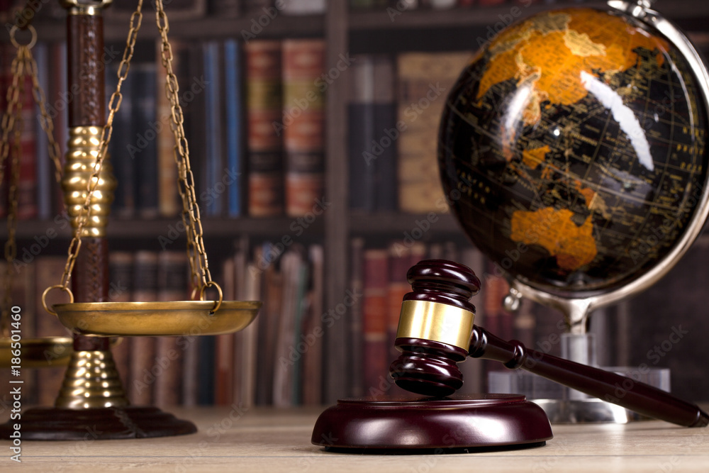 Judge's Gavel and scales of justice and law books in the background
