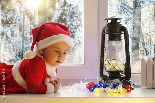 A child in the new year looks out the window. Children are waiti photo