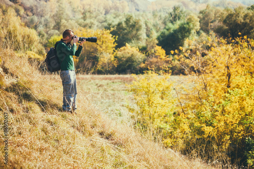 Photographer taking photos in mountain in autumn.  © djoronimo