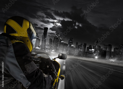 Detail of super-sport motorbike rider heading to the modern city