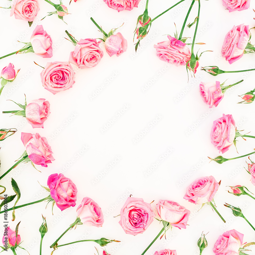 Round frame made of pink roses, branches and buds on white background. Flat lay, Top view. Valentines day composition