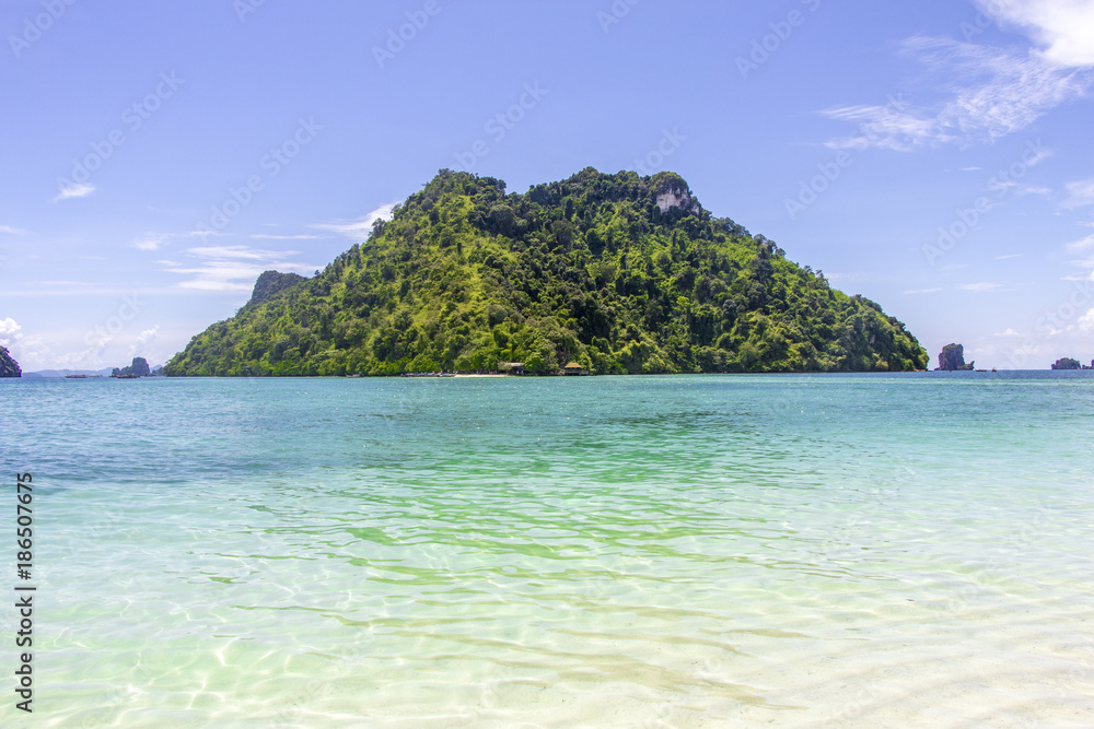 Mountain and sea view with three boats of tourist in front of the mountain and clear sky in Krabi, Thailand