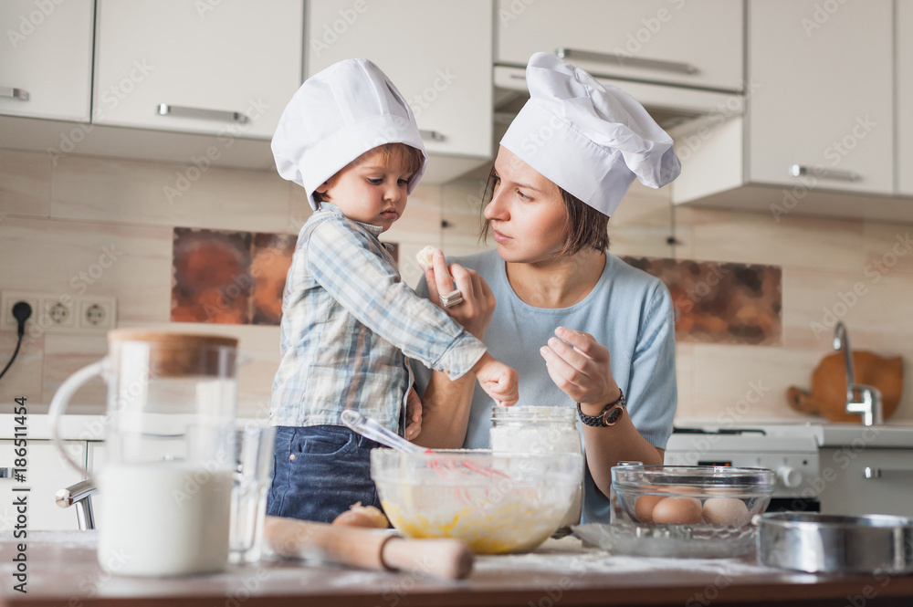 mother teaching her child how to prepare dough at kitchen mother teaching her child how to prepare dough at kitchen