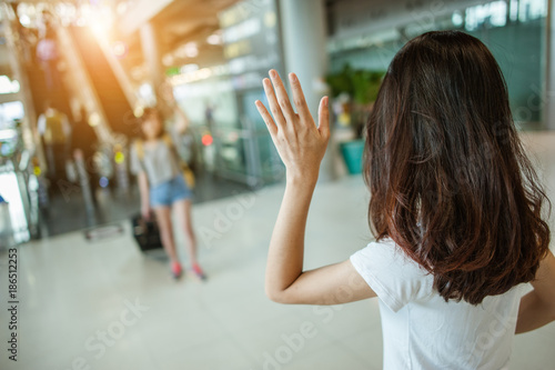 Asian girl say hi friends from abroad.airports concept.airports hug.Asian girl say goodbye friends.