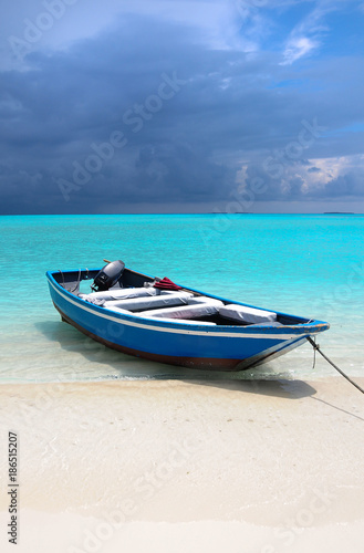 Blue Maldivian boat on the white sand beach © jennyrainbow