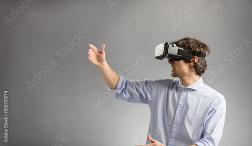 Young man playing in virtual reality goggles