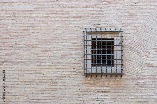 Window with iron grating on stone wall.