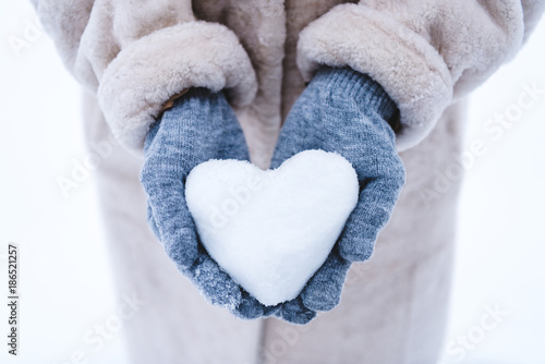 cropped shot of person holding heart symbol made from snow