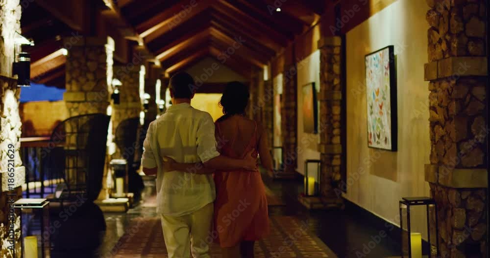 Couple enjoying vacation walking through luxury hotel at sunset Couple enjoying vacation walking through luxury hotel at sunset