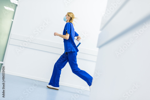 Canvastavla hurry female surgeon in medical masks with diagnosis running in hospital corrido