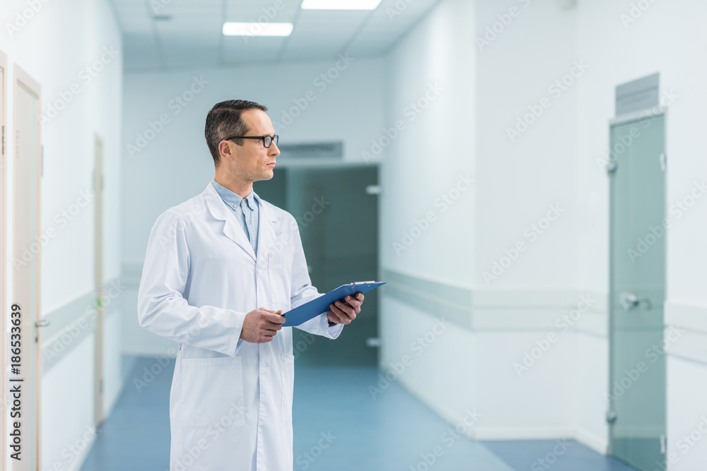 male doctor in white coat holding diagnosis in hospital