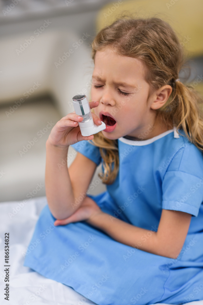ill kid using asthma inhaler with closed eyes ill kid using asthma inhaler with closed eyes