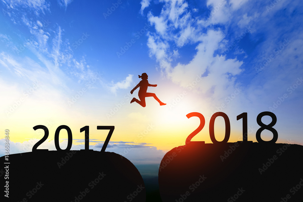 Woman jump through the gap between 2017 to 2018 on sunset. Woman jump through the gap between 2017 to 2018 on sunset.