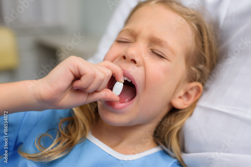 kid taking pill with closed eyes