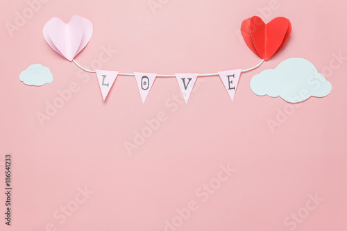 Flat lay image of decoration valentine's day background concept.Text sign of season with paper cut balloon love hang on beautiful pink sky with cloud.Several objects on pink wallpaper.pastel tone.