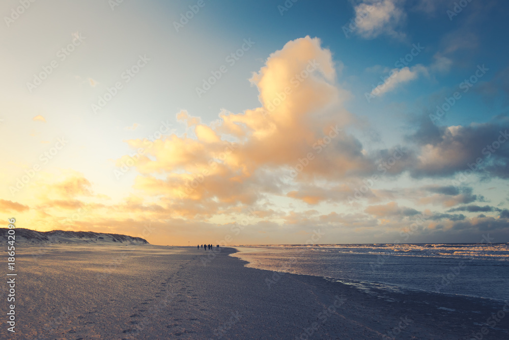 Gelbes Sonnenlicht über den Strand in der Abenddämmerung auf ostfriesischer Insel