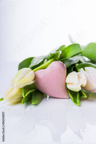 Tulips and pink heart on a light background. Free space