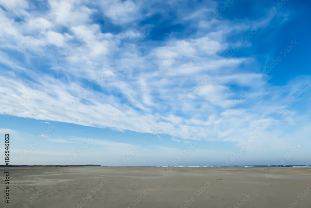 Blauer Himmel mit breitem Sandstrand an Nordseeküste