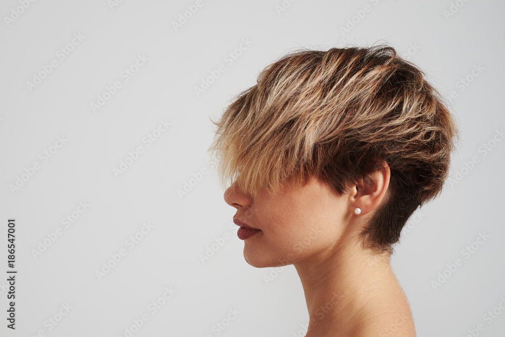 Beautiful blond woman with short hairstyle posing at studio - obrazy, fototapety, plakaty 