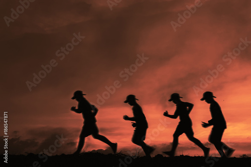 silhouette boys running sunset