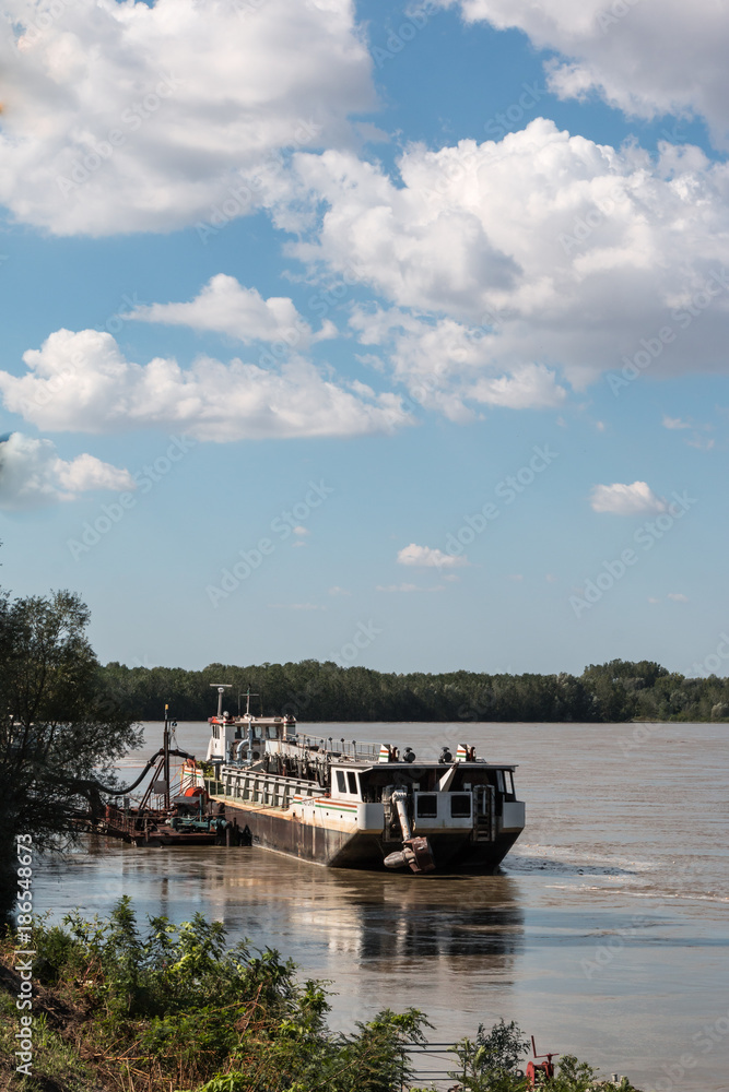 Abandoned Boat in River In Italy and sky with Clouds