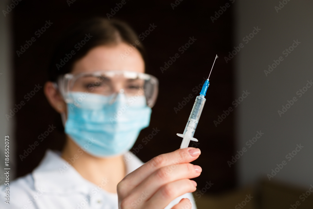 Woman doctor holding a syringe Woman doctor holding a syringe