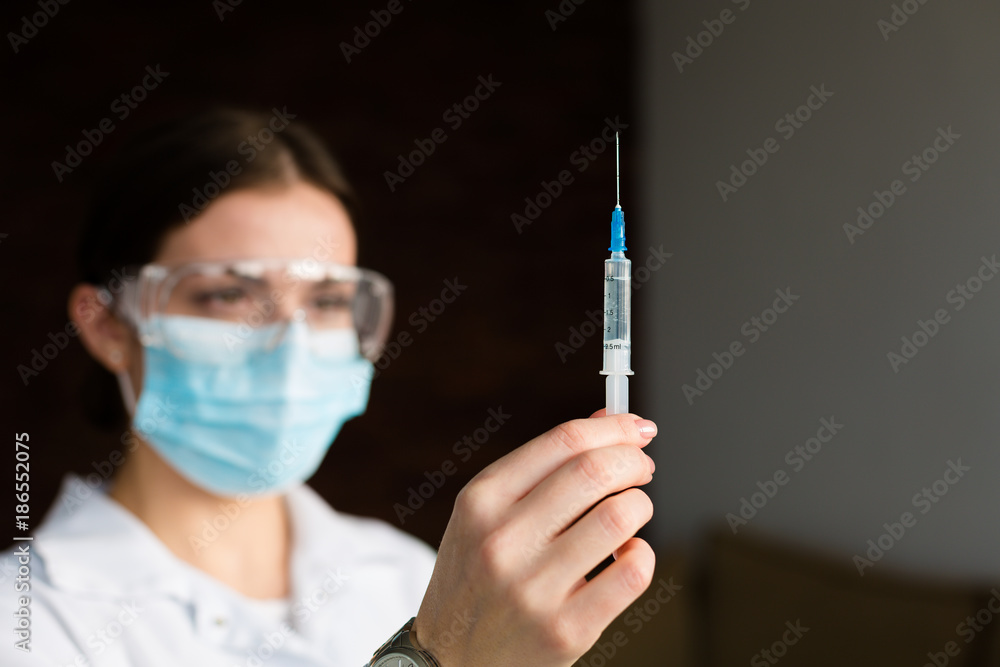 Woman doctor holding a syringe Woman doctor holding a syringe