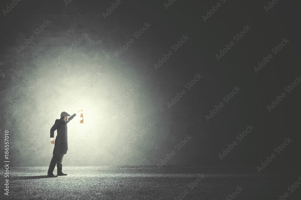 Man with lamp walking in the darkness