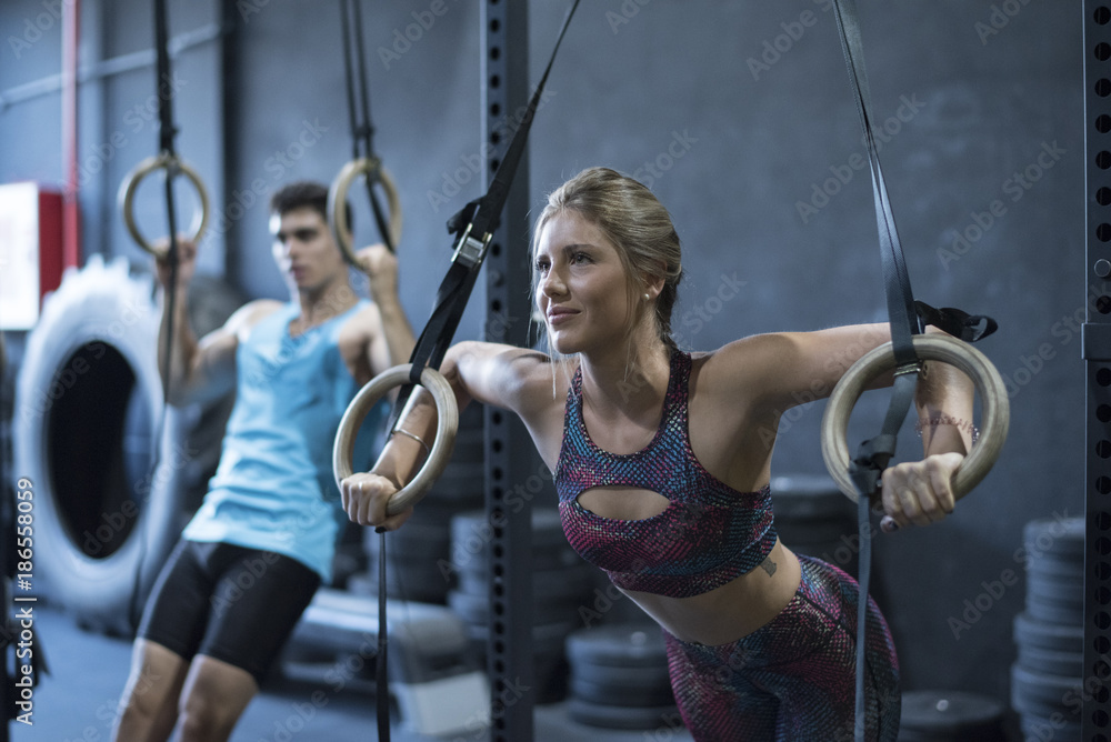 Obraz premium Ring training, Women training olympic ring in crossfit room with men
