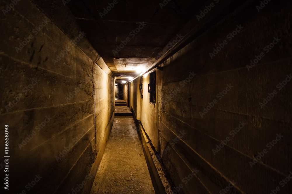 Dark corridor of old underground Soviet military bunker under artillery fortification.