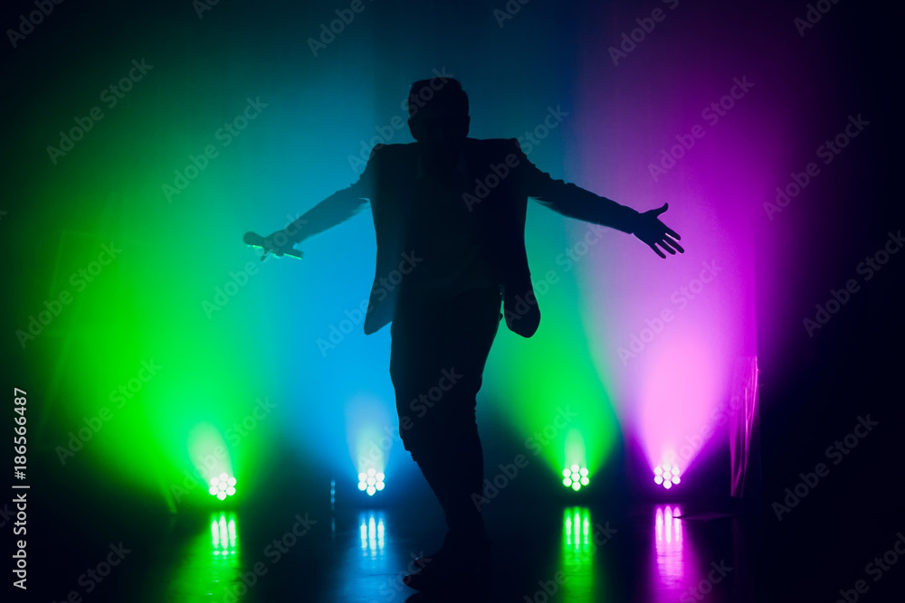 The entertainer. Young elegant talking man holding microphone - obrazy, fototapety, plakaty 