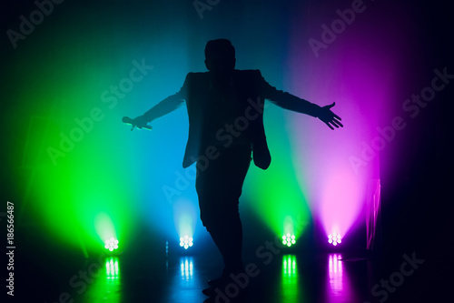 The entertainer. Young elegant talking man holding microphone photo