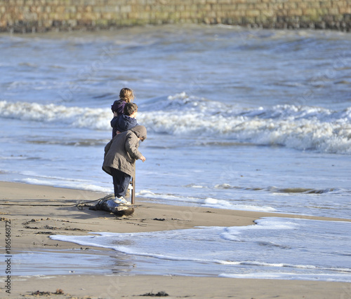 Enfants qui jouent avec l'écume de mer.