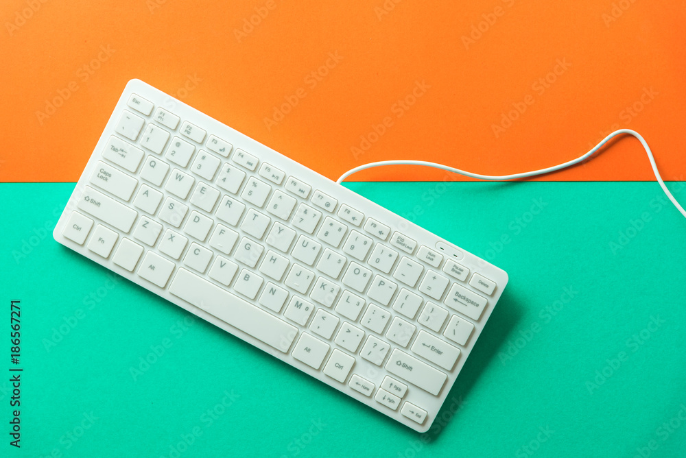 white computer keyboard on orange green background white computer keyboard on orange green background