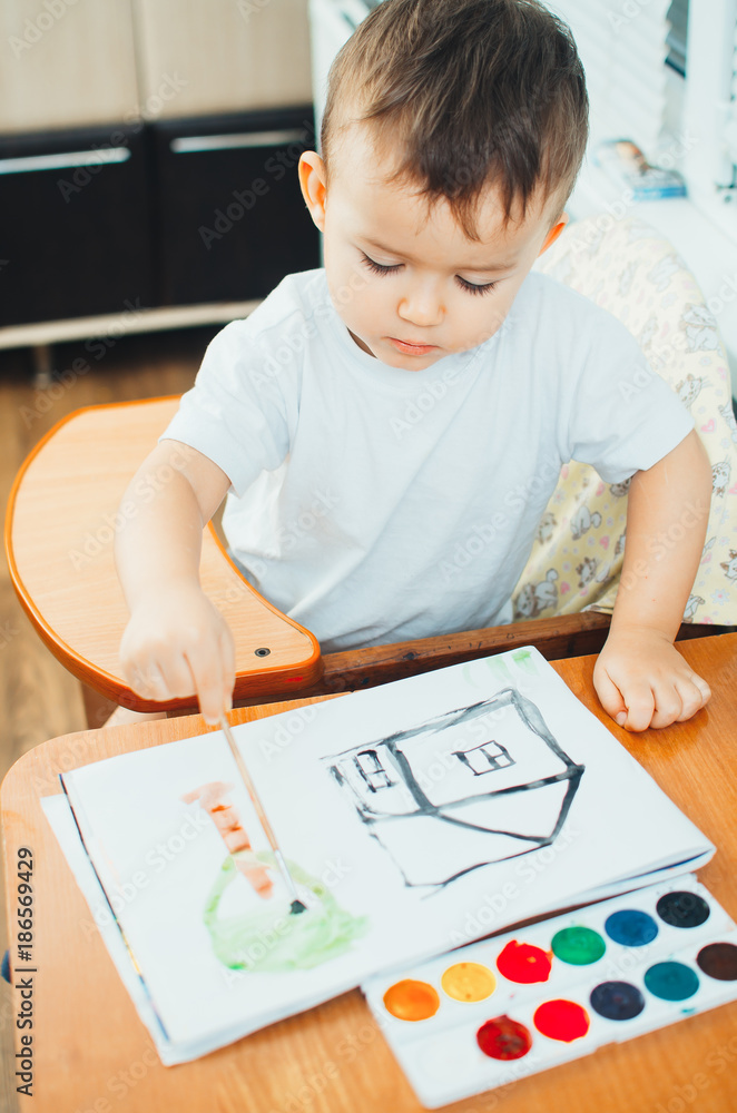 Charming baby in a child seat, draws and Charming baby in a child seat, draws and