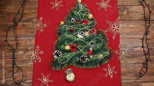 a small Christmas tree of tinsel, nuts, ribbons and ornaments. Gift for a Christmas tree, a vintage watch. 2018,