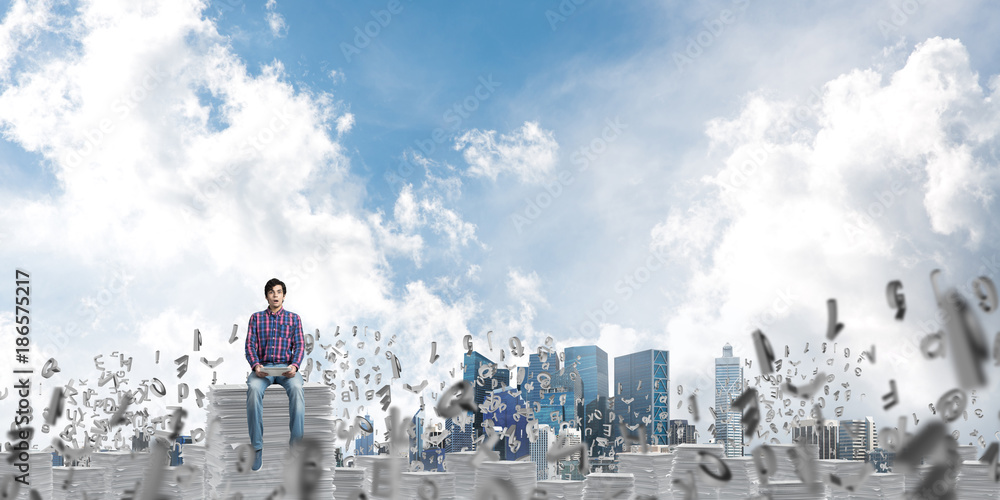 Attractive man sitting on pile of paper documents. Attractive man sitting on pile of paper documents.