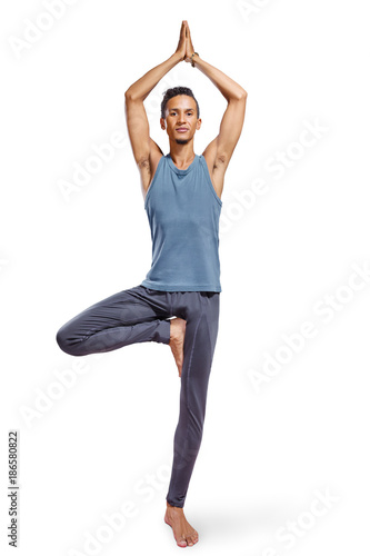 Young man doing yoga isolated on white