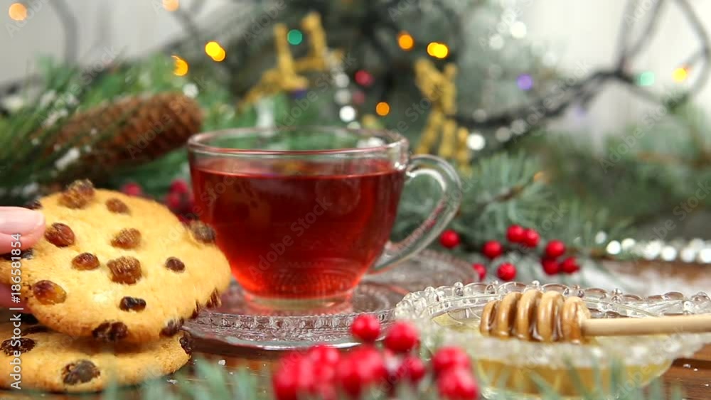 a cup of tea with honey and cookies, a branch of a Christmas tree in the snow, Christmas lights a cup of tea with honey and cookies, a branch of a Christmas tree in the snow, Christmas lights