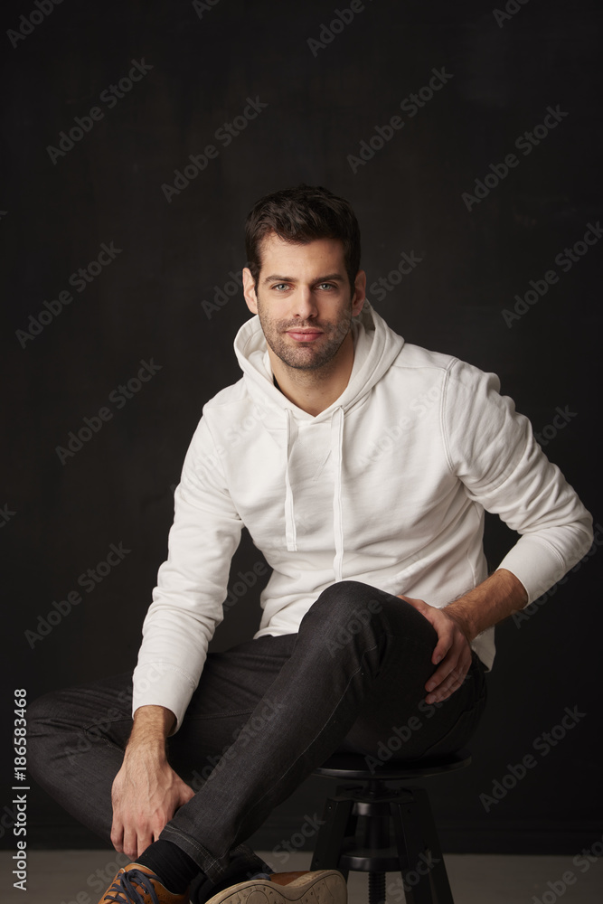 Studio shot of a handsome young man against dark grey background Studio shot of a handsome young man against dark grey background