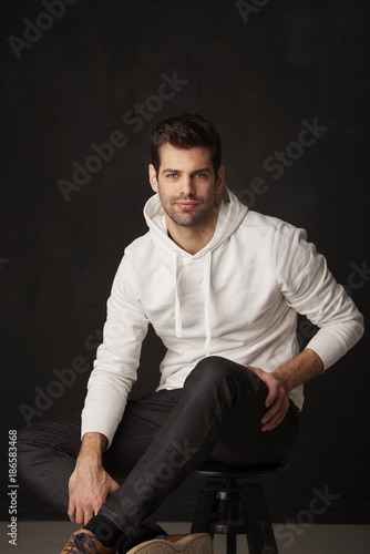 Studio shot of a handsome young man against dark grey background 
